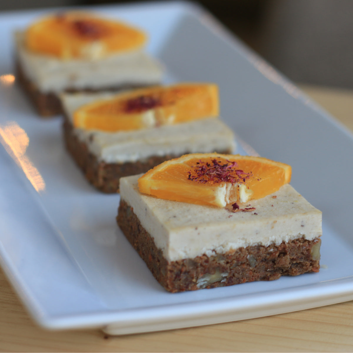 Raw vegansk morotskaka med valnötsbotten och len citroncashew-kokosgräddkräm