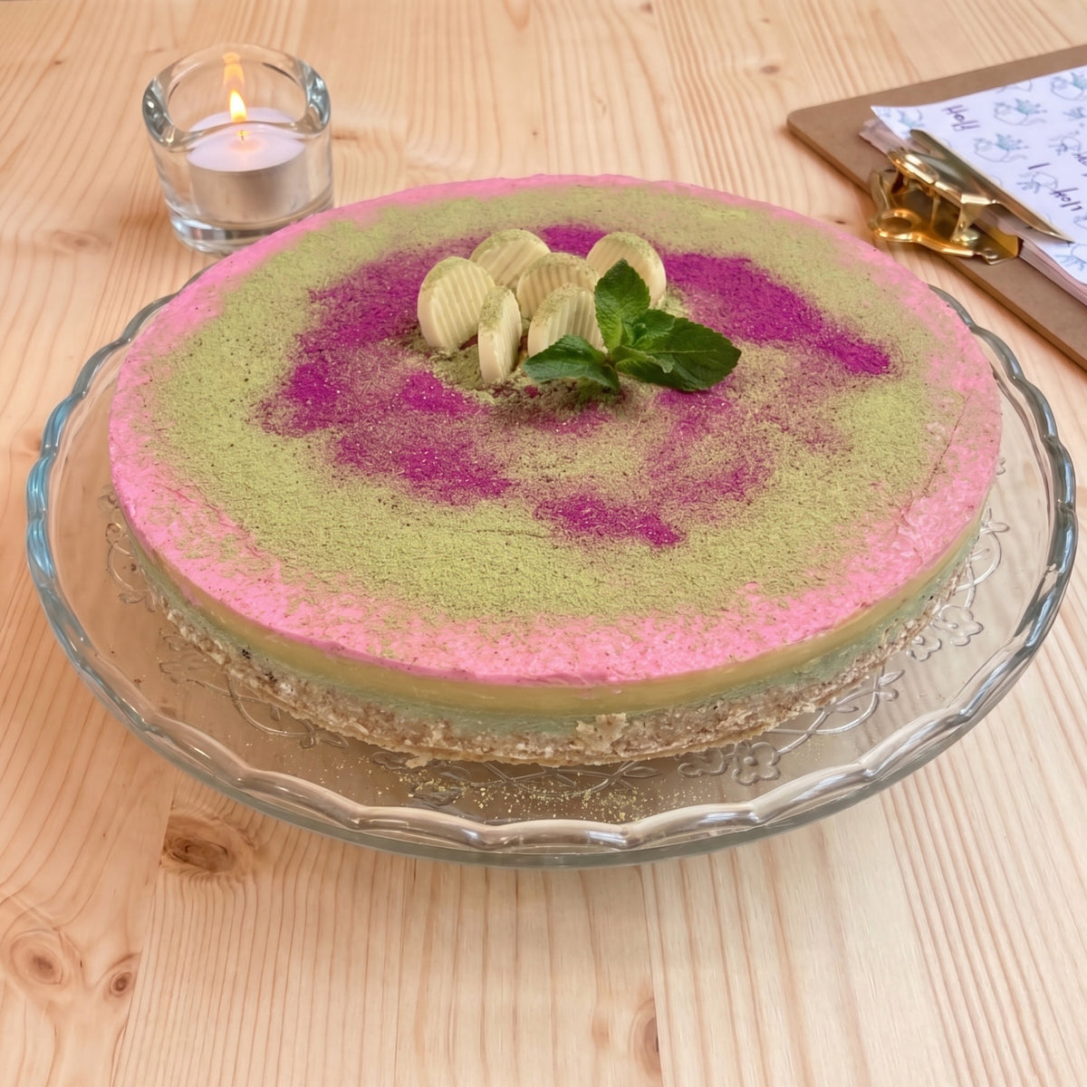 Raw kaka med mandelbotten, matcha-cashewfyllning och vitchokladkräm. Räcker till 10–12. Växtbaserad & glutenfri.