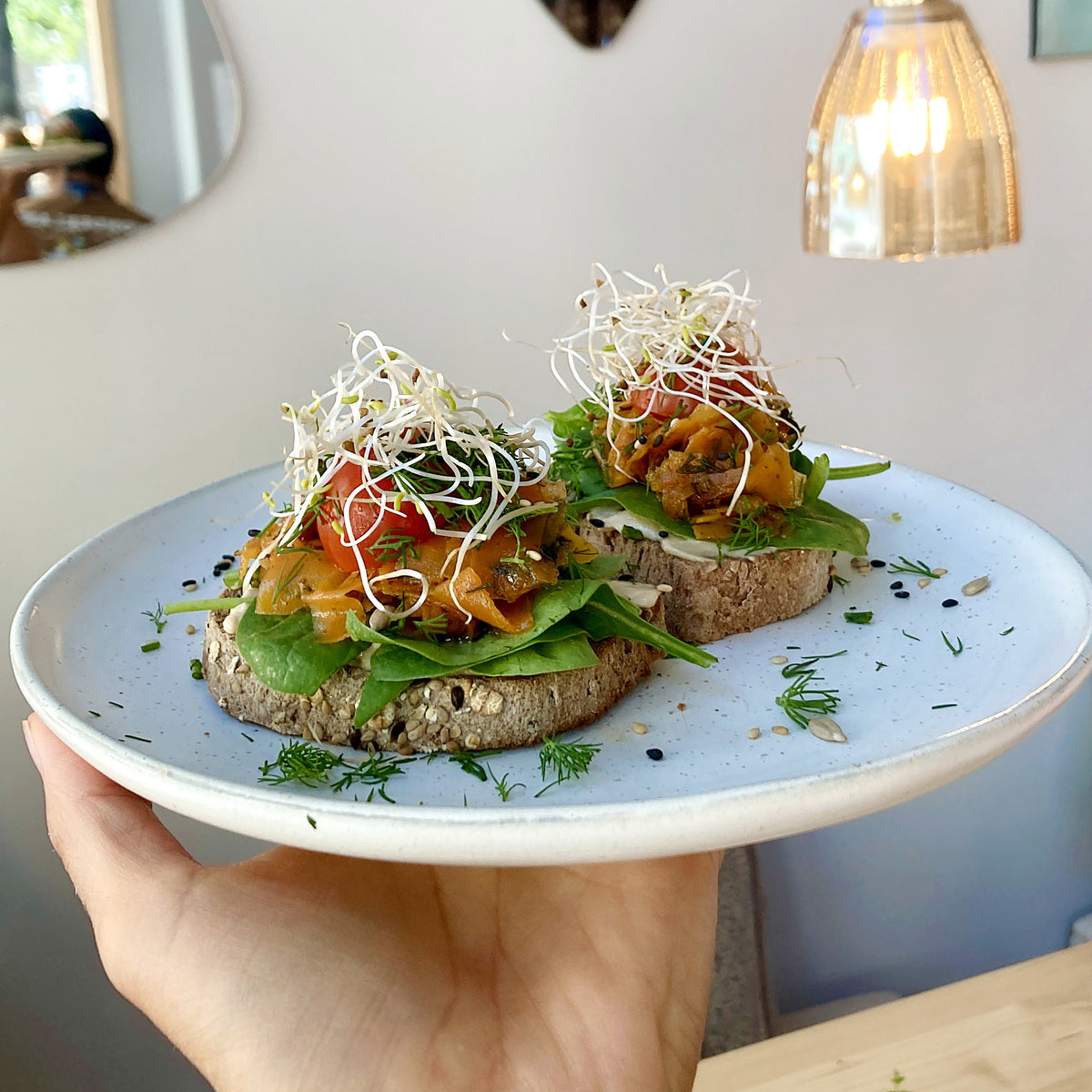 Asiatisk marinerad morot-”lax” på färsk spenat med hemgjord cashew-färskost. Serveras på två skivor av vårt hembakade rostat bröd.